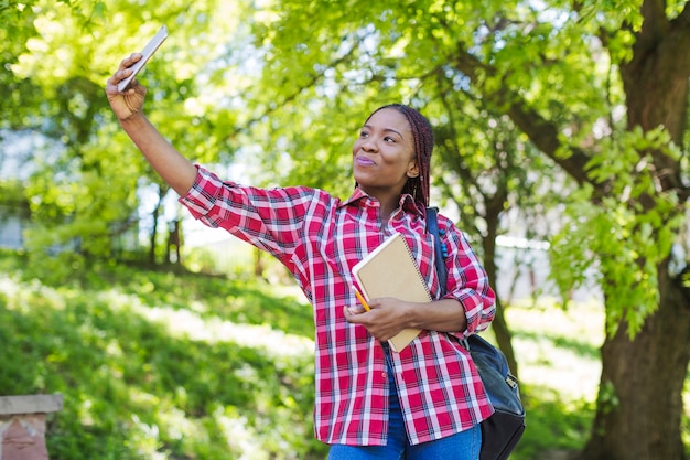 Jeune fille prenant selfie avec des manuels scolaires