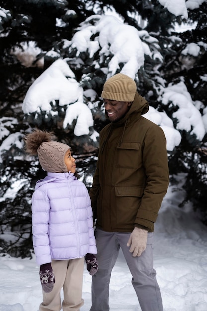 Photo gratuite jeune fille profitant d'une journée d'hiver à l'extérieur avec son père