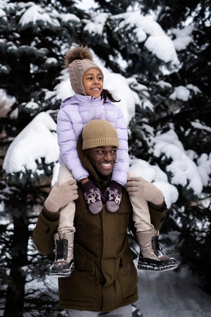 Photo gratuite jeune fille profitant d'une journée d'hiver à l'extérieur avec son père