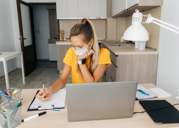 Jeune fille qui étudie à la maison