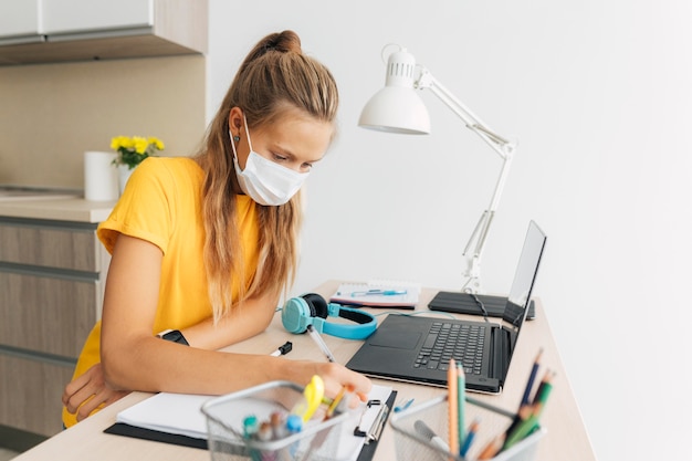 Jeune fille qui étudie à la maison