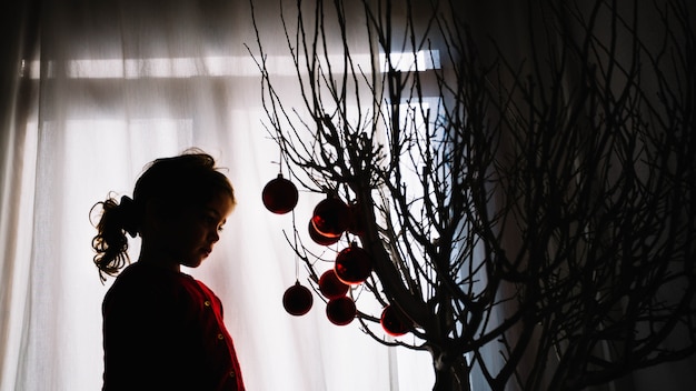 Photo gratuite jeune fille à la recherche de sapin de noël