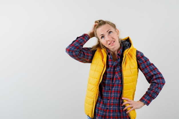 Jeune fille réfléchie se grattant la tête sur fond blanc