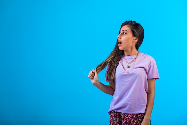 La jeune fille regarde vers la gauche et surprise.