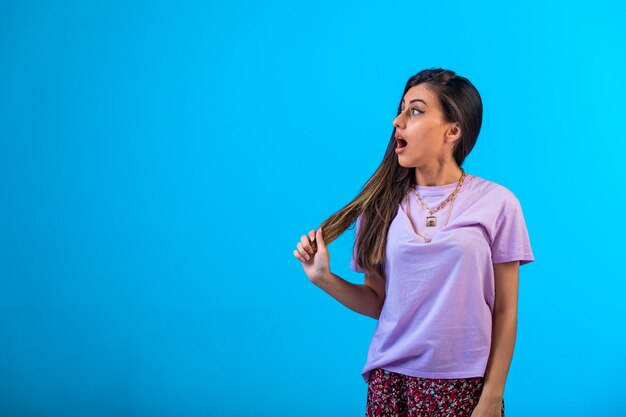 La jeune fille regarde vers la gauche et surprise.