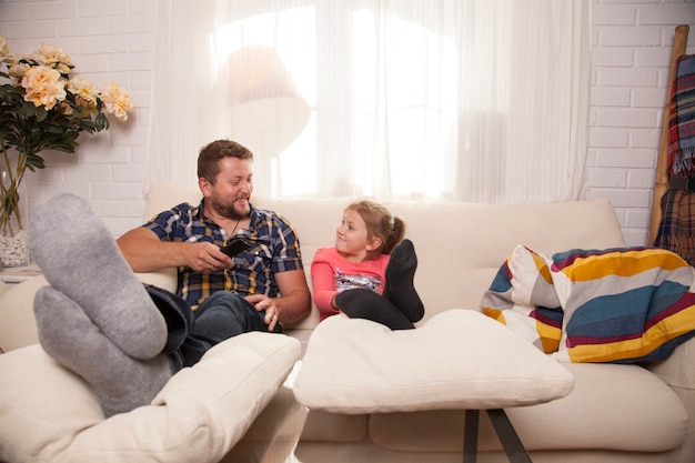 Jeune fille relaxant sur le canapé avec son père