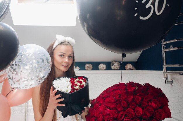 Jeune fille riant et appréciant de beaux cadeaux à la maison