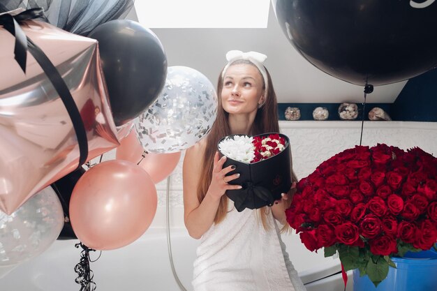 Jeune fille riant et appréciant de beaux cadeaux à la maison