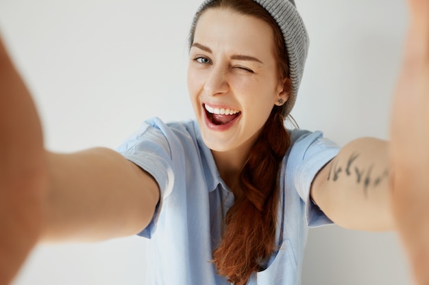 Jeune fille rousse portant chapeau et chemise bleue