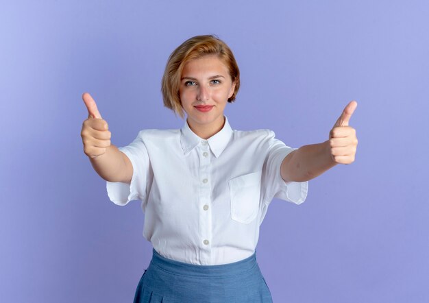 Jeune fille russe blonde heureuse Thumbs up avec les deux mains isolé sur fond violet avec copie espace