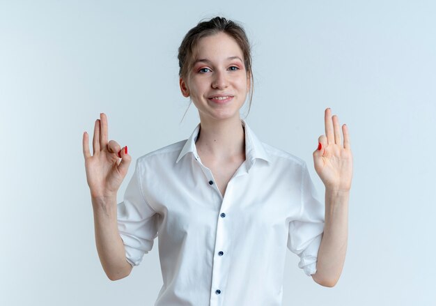 Jeune fille russe blonde souriante gestes ok signe de la main avec deux mains isolé sur un espace blanc avec copie espace