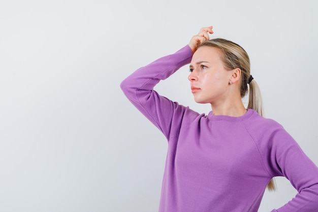 Jeune fille se grattant la tête et pensant sur fond blanc