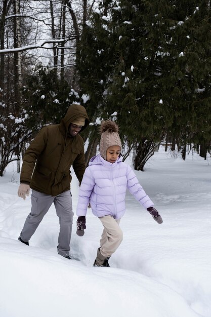 Jeune fille se promenant avec son père en hiver