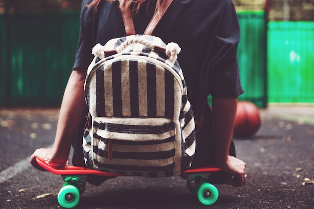 Jeune fille, séance, sur, plastique, orange, penny, shortboard, sur, asphalte, dans, casquette