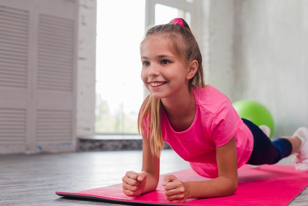 Jeune fille souriante blonde faisant des exercices de fitness