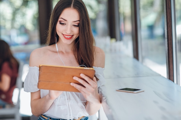 Jeune fille souriante avec un casque et une tablette