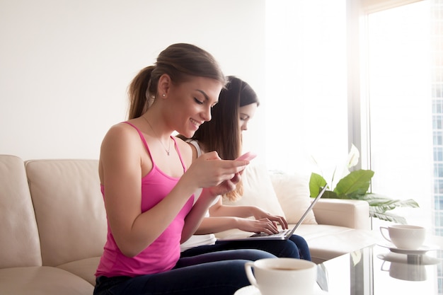 Jeune fille souriante excitée de recevoir un message sur smartphone.