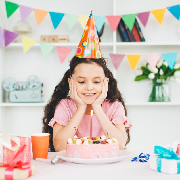 Jeune fille souriante avec un gâteau d&#39;anniversaire