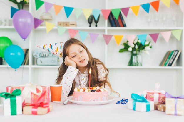 Jeune fille souriante avec un gâteau d&#39;anniversaire