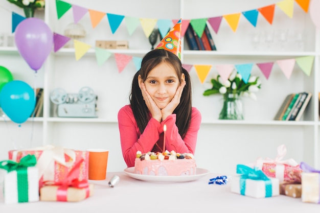 Jeune fille souriante avec un gâteau d&#39;anniversaire