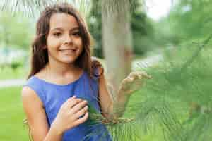 Photo gratuite jeune fille souriante qui pose dans la nature