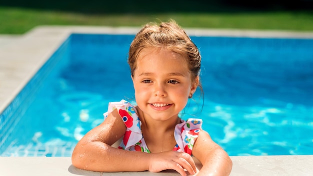 Jeune fille souriante se tenant au bord de la piscine