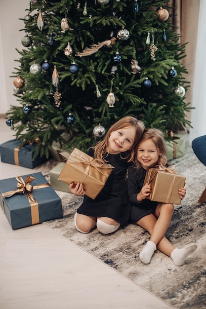 Jeune fille souriante tenant leurs cadeaux de Noël dans des cadeaux d'emballage marron