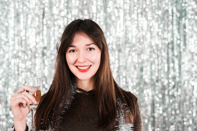 Photo gratuite jeune fille souriante avec un verre à la fête du nouvel an