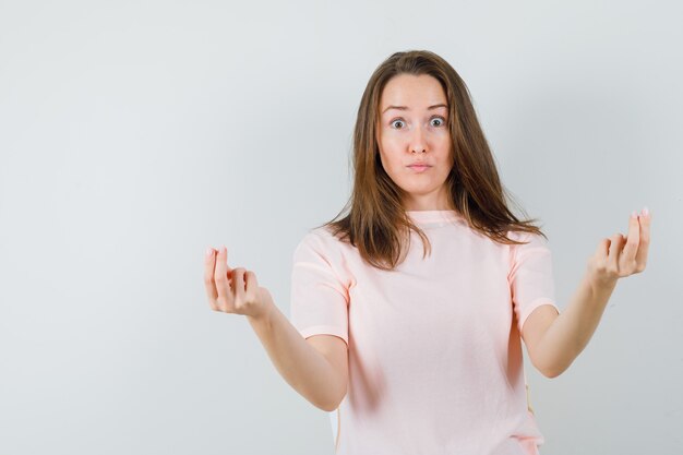 Jeune fille en t-shirt rose faisant un geste d'argent et à la vue de face excitée.