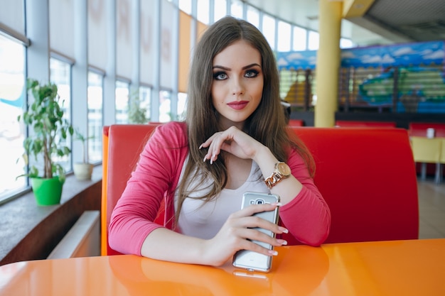 Jeune fille avec un téléphone mobile dans la main