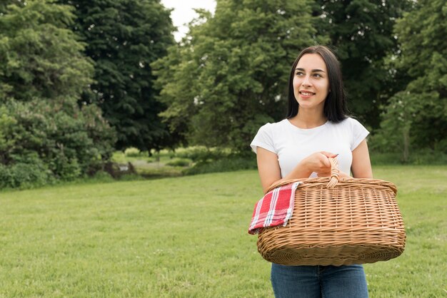 Jeune fille tenant un panier pique-nique