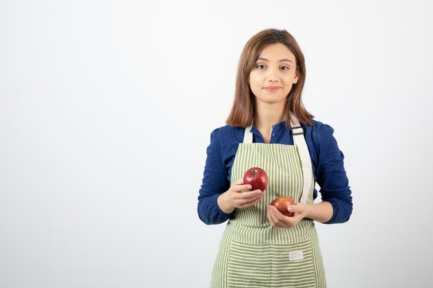 jeune fille tenant des pommes rouges sur blanc.