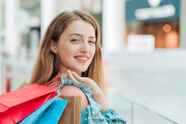 Jeune fille tenant des sacs à provisions se bouchent