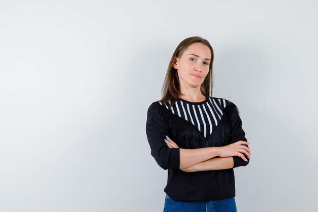 Jeune fille tenant ses bras ensemble sur fond blanc