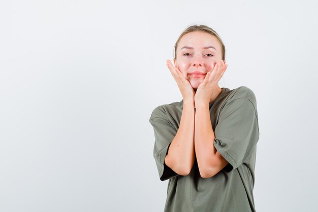 Jeune fille tenant ses mains sur ses joues sur fond blanc