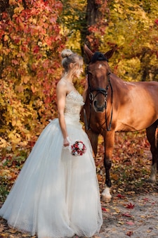 Jeune fille tendre mariée posant près de la forêt d'automne