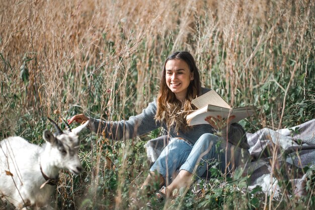 jeune fille sur un terrain lisant un livre