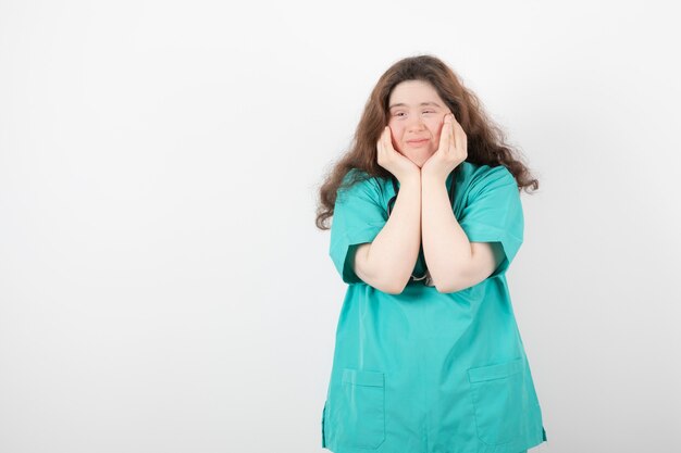 jeune fille en uniforme vert debout et posant.