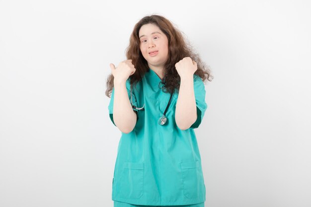 jeune fille en uniforme vert avec stéthoscope debout et posant.