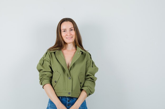 Jeune fille en veste, short et à la séduisante, vue de face.