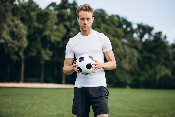 Photo gratuit jeune footballeur sur le terrain de football
