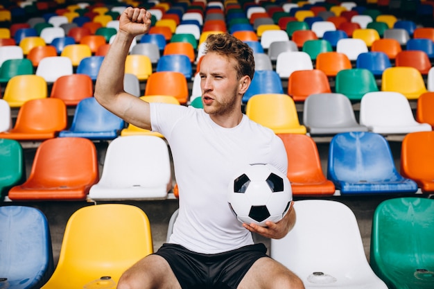 Jeune footballeur sur les tribunes en regardant le match