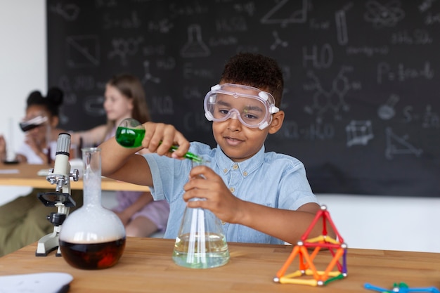 Jeune garçon apprenant plus sur la chimie en classe