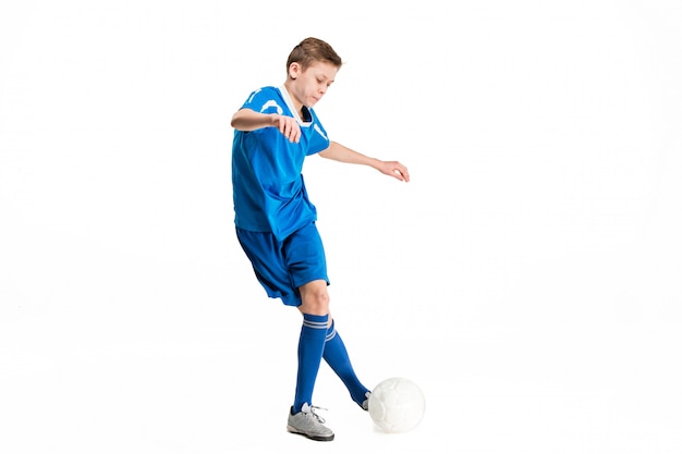 Jeune garçon avec un ballon de soccer faisant voler coup de pied