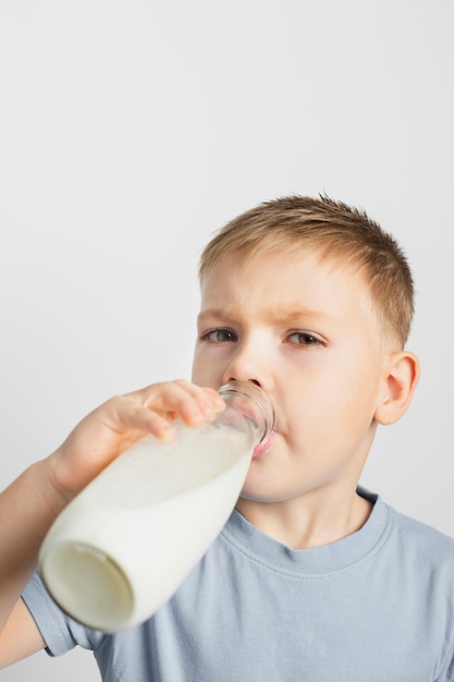 Jeune garçon buvant du lait en bouteille