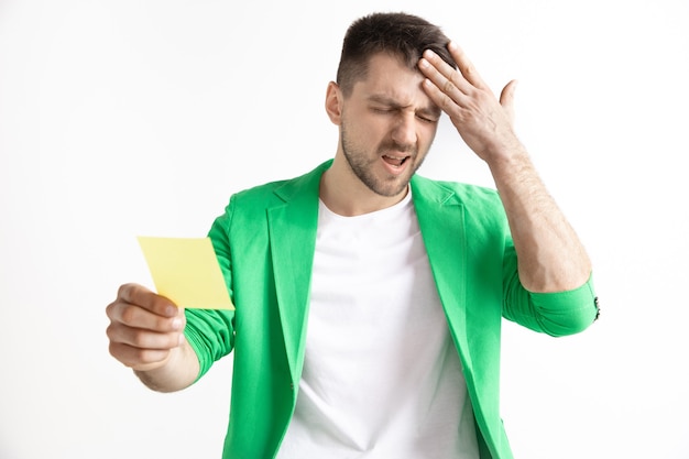 Photo gratuite jeune garçon avec une expression d'échec malheureux surpris pari sur fond de studio.