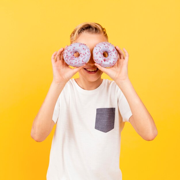 Jeune garçon, fabrication, lunettes, beignets