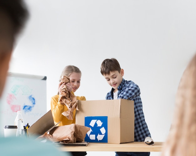 Jeune garçon et fille apprenant à recycler