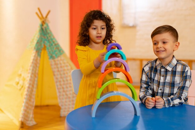 Jeune garçon et fille jouant à l'intérieur avec des jouets écologiques