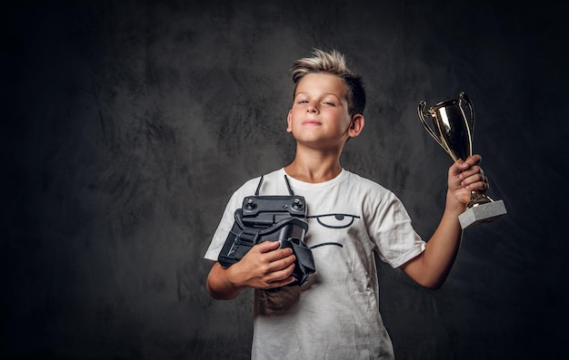 Un jeune garçon heureux a remporté le concours de jeux de réalité virtuelle et a remporté la coupe.